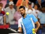 Novak Djokovic, of Serbia, hits tennis balls into the crowd after he defeated Gael Monfils, of France.
