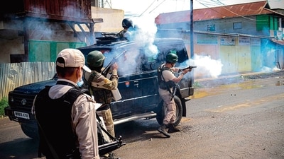 Security personnel fire tear gas shells to disperse those protesting for withdrawal of central forces, in Imphal East on August 16. (AFP) Security personnel fire tear gas shells to disperse those protesting for withdrawal of central forces, in Imphal East on August 16. (AFP)