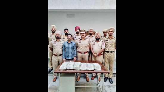 The accused in police custody of Lalru police with the recovered ₹50 lakh unaccounted cash. (HT Photo)