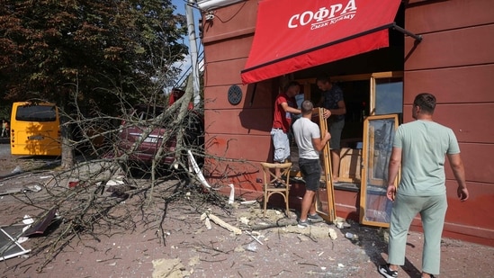 Local residents clear debris at the site of a missile strike in Chernihiv, (AFP)