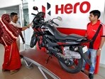Customers look at a Hero MotoCorp Karizma motorbike at a Hero MotoCorp showroom.