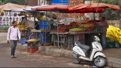 Fruit and vegetable vendors stand illegally over footpaths and roads both within and outside the market, hindering the smooth flow of vehicles and pedestrians. (Manish/HT) Fruit and vegetable vendors stand illegally over footpaths and roads both within and outside the market, hindering the smooth flow of vehicles and pedestrians. (Manish/HT)