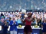 Coco Gauff, of the United States, raises the Rookwood Cup after defeating Karolina Muchova, of Czech Republic