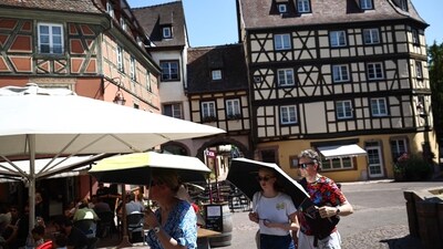 France Heatwave: People protect themselves from the sun under umbrellas in Colmar, eastern France. (AFP) France Heatwave: People protect themselves from the sun under umbrellas in Colmar, eastern France. (AFP)
