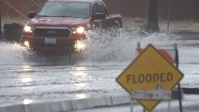 A vehicle drives through a flooded road as Tropical Storm Hilary moves through the area on August 20, 2023 in Palm Springs, California.&nbsp; (AFP)