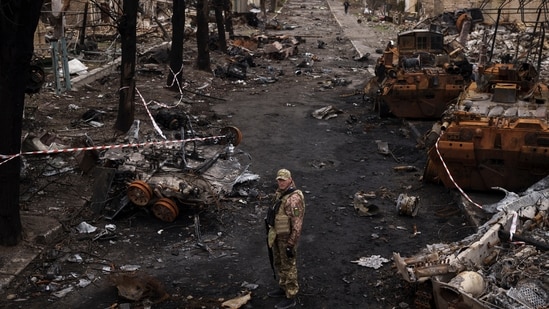 Russia-Ukraine War: A Ukrainian serviceman stands amid destroyed Russian tanks in Bucha, on the outskirts of Kyiv, Ukraine. (AP)