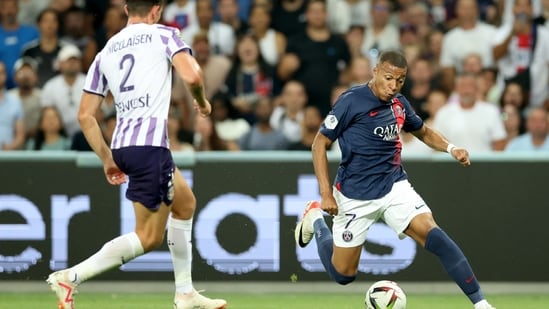 Toulouse's Danish defender Rasmus Nicolaisen and Paris Saint-Germain's French forward Kylian Mbappe fight for the ball. (AFP)