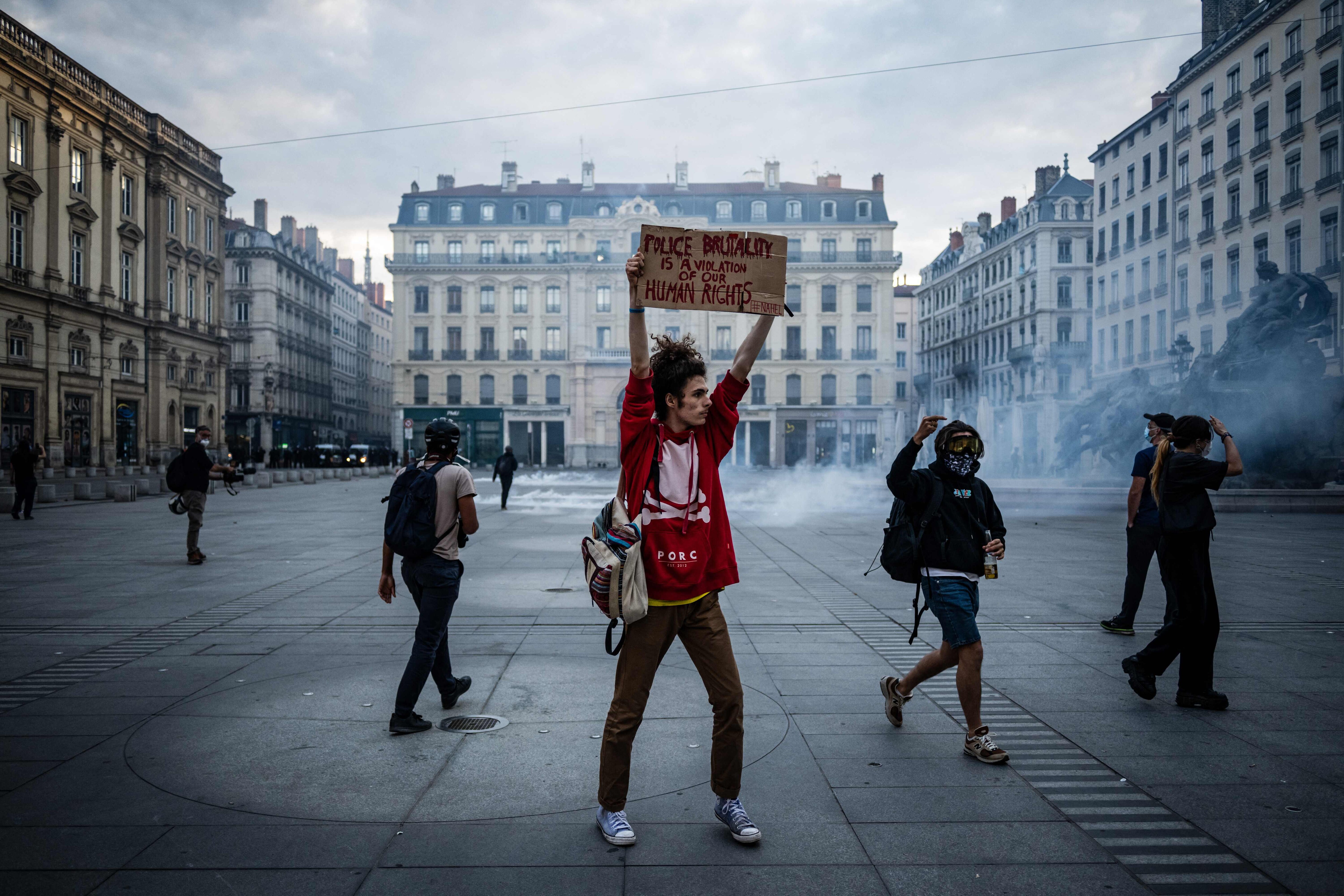 A protester holds a placard Place des Terreaux in Lyon on June 30, 2023, as unrest erupted following the shooting of a teenage driver by French police in a Paris suburb on June 27. The unrest has come in response to the killing of 17-year-old Nahel, whose death has revived longstanding grievances about policing and racial profiling in France's low-income and multi-ethnic suburbs. (Jeff Pachoud/AFP)