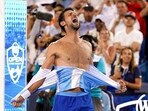 Novak Djokovic, of Serbia, rips his shirt in celebration after defeating Carlos Alcaraz, of Spain, at the conclusion of the men's singles final of the Western & Southern Open