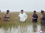 North Korea's leader Kim Jong Un in waste-deep water as he visits the restoration site of reclaimed land which suffered flood damage.