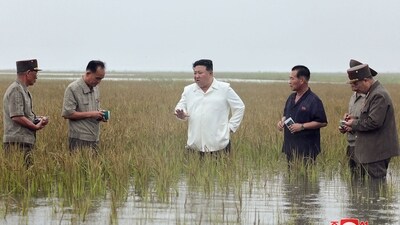 North Korea's leader Kim Jong Un in waste-deep water as he visits the restoration site of reclaimed land which suffered flood damage. (AFP)