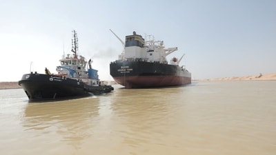 A tugboat works to refloat the Oil Products Tanker BURRI after it collided with LNG Tanker BW Lesmes in the waterway of the Suez Canal, (via REUTERS)