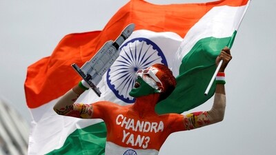 Arun Haryani, an enthusiast with his body painted in tri-colours reacts as he holds up a model of LVM3 M4 which was used in launching of Chandrayaan-3 (REUTERS)