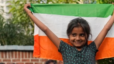 A girl stands with the Indian national flag as she watches a live telecast of the landing of Chandrayaan-3. (AP) A girl stands with the Indian national flag as she watches a live telecast of the landing of Chandrayaan-3. (AP)