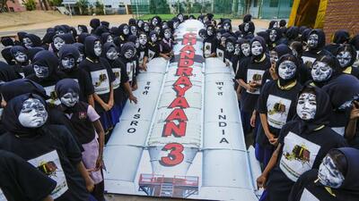 Schoolchildren with painted faces surround a replica of the Chandrayaan-3 spacecraft. The lander module of Chandrayaan 3, the Indian Space Research Organisation’s third moon mission, is set to attempt landing on the lunar mission on Wednesday evening. (PTI Photo)