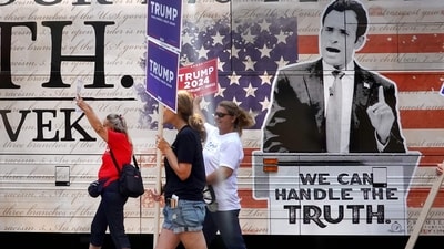 Supporters of Republican presidential candidate former President Donald Trump carry signs past a campaign bus of Republican presidential candidate businessman Vivek Ramaswamy parked near the Fiserv Forum on August 22, 2023 in Milwaukee, Wisconsin. (Getty Images via AFP) Supporters of Republican presidential candidate former President Donald Trump carry signs past a campaign bus of Republican presidential candidate businessman Vivek Ramaswamy parked near the Fiserv Forum on August 22, 2023 in Milwaukee, Wisconsin. (Getty Images via AFP)