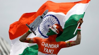 Chandrayaan 3 landing: An enthusiast with his body painted in tri-colours reacts as he holds up a model of LVM3 M4 which was used to launch India's third lunar spacecraft. (REUTERS)