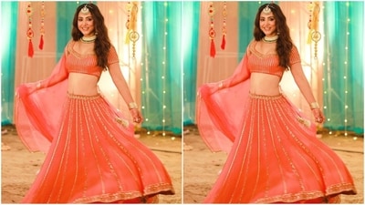 Her orange lehenga is from designer Esha Koul and features a half-sleeved blouse with a sweetheart neckline and horizontal gold embroidered sequins all over. She paired it with a matching flared skirt and netted dupatta. (Instagram/@realhinakhan)