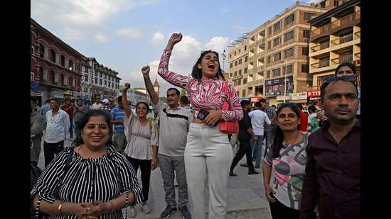 People cheer as they celebrate the successful lunar landing of Chandrayaan-3 spacecraft on the south pole of the Moon after watching a live telecast of the event near a clock tower in Srinagar on Wednesday. (AFP)