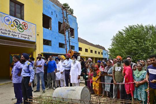 People gather outside the school building as the rescue operation was being carried out on Wednesday. (Gurpreet Singh/HT) People gather outside the school building as the rescue operation was being carried out on Wednesday. (Gurpreet Singh/HT)