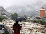A man looks at a swollen Beas River following heavy rains in Kullu, Himachal Pradesh.