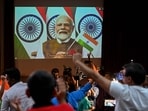 People wave India's national flag as India's Prime Minister Narendra Modi (C screen) congratulates the Indian Space Research Organisation (ISRO) for the successful lunar landing of Chandrayaan-3. People wave India's national flag as India's Prime Minister Narendra Modi (C screen) congratulates the Indian Space Research Organisation (ISRO) for the successful lunar landing of Chandrayaan-3.