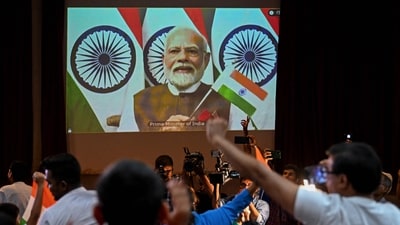 People wave India's national flag as India's Prime Minister Narendra Modi (C screen) congratulates the Indian Space Research Organisation (ISRO) for the successful lunar landing of Chandrayaan-3. (AFP) People wave India's national flag as India's Prime Minister Narendra Modi (C screen) congratulates the Indian Space Research Organisation (ISRO) for the successful lunar landing of Chandrayaan-3. (AFP)
