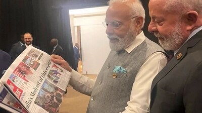 PM Modi going through an African newspaper report on Chandrayaan 3 on Thursday morning in Johannesburg.