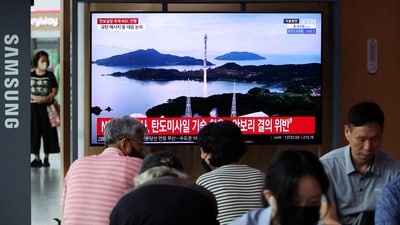 Passengers watch a TV broadcasting a news report on North Korea firing a space rocket, at a railway station in Seoul, South Korea, August 24, 2023. (Reuters)