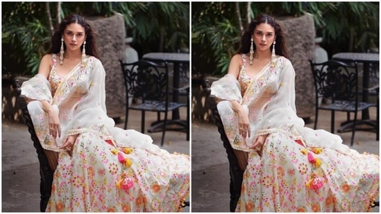 Aditi looked elegant in a white sleeveless blouse featuring mirror work and embroidery details in shades of multiple colours. In a matching long and flowy skirt and an organza dupatta with mirror and embroidery work and zari work at the worders, she completed her look.&nbsp;(Instagram/@aditiraohydari)