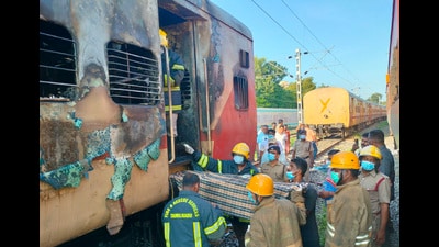 Firefighters hold a stretcher to carry bodies from a train coach where fire erupted in Madurai on Saturday. (AP) Firefighters hold a stretcher to carry bodies from a train coach where fire erupted in Madurai on Saturday. (AP)