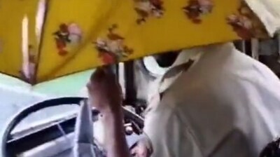 Bus driver holds umbrella while driving (X/INCMumbai) Bus driver holds umbrella while driving (X/INCMumbai)