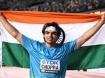 Gold medalist, India's Neeraj Chopra celebrates with his National flag after the men's javelin throw final during the World Athletics Championships at the National Athletics Centre in Budapest on August 27, 2023. (Photo by Kirill KUDRYAVTSEV / AFP)
