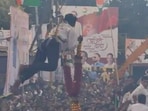 NCP supporter hangs from crane to garland Ajit Pawar. NCP supporter hangs from crane to garland Ajit Pawar.