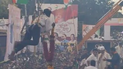NCP supporter hangs from crane to garland Ajit Pawar.
