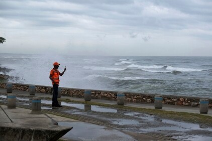 A man takes photos with his phone as the waves caused by Tropical Storm Franklin break on the sea wall in Santo Domingo, Dominican Republic, Tuesday, Aug. 22, 2023. AP/PTI(AP08_23_2023_000003B) (AP) A man takes photos with his phone as the waves caused by Tropical Storm Franklin break on the sea wall in Santo Domingo, Dominican Republic, Tuesday, Aug. 22, 2023. AP/PTI(AP08_23_2023_000003B) (AP)