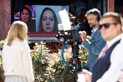 Members of the media work near a large screen showing a picture of convicted hospital nurse Lucy Letby, ahead of her sentencing, outside the Manchester Crown Court, in Manchester, Britain, August 21, 2023 (REUTERS/Phil Noble) (REUTERS)