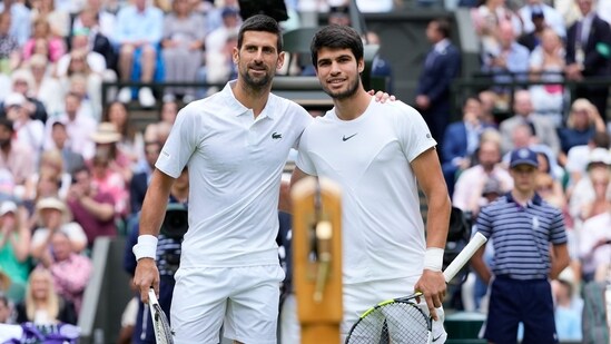 Serbia's Novak Djokovic, left, and Spain's Carlos Alcaraz pose for a photo ahead of the final of the men's singles on day fourteen of the Wimbledon tennis championships in London (AP)
