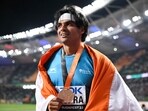 Gold medalist, India's Neeraj Chopra celebrates with his National flag and medal after the men's javelin throw final during the World Athletics Championships at the National Athletics Centre in Budapest 
