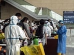 Arriving travelers queue for Covid-19 tests at Changshui International Airport in Kunming, China