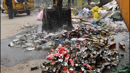 A JCB machine crushes liquor bottles seized in Patna, Bihar. (Santosh Kumar/ HT File Photo)