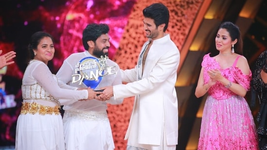 Vijay Deverakonda presents the trophy to Sandeep and Jyothi.