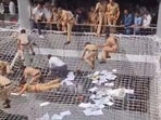 Police personnel pull back the farmers who jumped on the safety nets during a protest against low compensation for their land in the Mantralaya building, Police personnel pull back the farmers who jumped on the safety nets during a protest against low compensation for their land in the Mantralaya building,