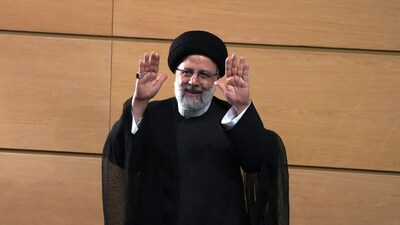 Iranian President Ebrahim Raisi waves to the media as he leaves after a press conference in Tehran, Iran. (AP)