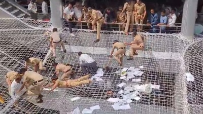 Police personnel pull back the farmers who jumped on the safety nets during a protest against low compensation for their land in the Mantralaya building, (PTI) Police personnel pull back the farmers who jumped on the safety nets during a protest against low compensation for their land in the Mantralaya building, (PTI)