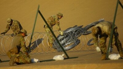 Members of the Texas National Guard place wire fence on the banks of the Rio Bravo river, the border between the United States and Mexico, with the purpose of reinforcing border security and inhibiting the crossing of migrants into the United States, as seen from Ciudad Juarez, Mexico, August 22, 2023. (REUTERS)