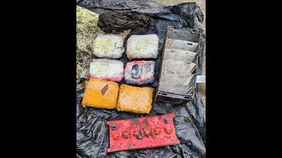 The packets of narcotics and the battery in which they were concealed near the border fence at Dostpur village in Gurdaspur district. (HT Photo)