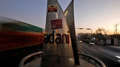 Traffic moves past the logo of the Adani Group installed at a roundabout on the ring road in Ahmedabad, India. (REUTERS)