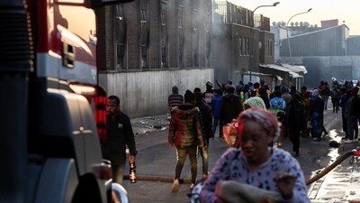People walk past a building after a deadly blaze in the early hours of the morning, in Johannesburg, South Africa August 31. (REUTERS)