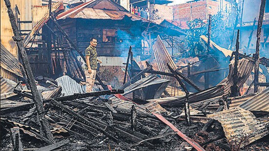 A man stands amid the charred remains of houses burned down, during the ongoing ethnic violence, in Imphal on August 27. (AFP)